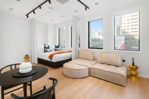 a bedroom with a bed and a couch and a table at Victoria Street Apartments by Urban Rest in Auckland