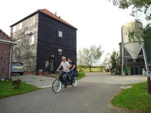 dos personas en bicicleta por una calle en Hoeve Meerzicht, en Monnickendam