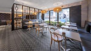 a restaurant with tables and chairs and windows at Perth's Premie King Deluxe in Perth