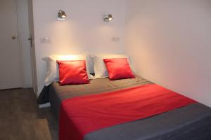 a bedroom with two red pillows on a bed at Le Kleber in Montreuil