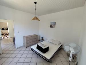 Un dormitorio con una cama, una silla y una lámpara. en Maison 8 couchages Arcachon, en Arcachon