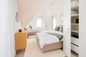 a bedroom with two beds and a staircase at STAYY Flagship Limmattal - contactless check-in in Schlieren