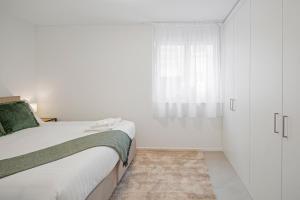 A bed or beds in a room at STAYY Flagship Limmattal - contactless check-in