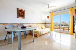 a living room with a table and a couch at Cap Roig, Appartement Duplex in L'Ampolla