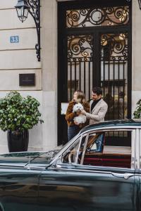 a man and a woman standing outside a building with a dog at Maison Villeroy in Paris