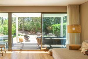 a living room with a view of a patio with a tub at Villa Mar in Troia