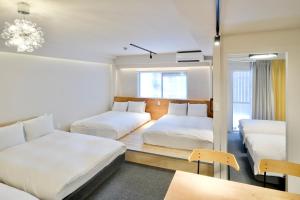 大阪市にある難波 ハラ アパートメントのベッド2台とテーブルがあるホテルの部屋