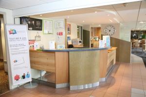 a counter in a store with a clock on the wall at ibis Styles Orléans in La Chapelle-Saint-Mesmin