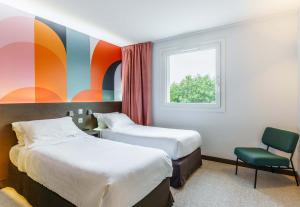 a hotel room with two beds and a window at B&B HOTEL Saint-Avold Nord in Saint-Avold +22 photos
