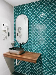 une salle de bain avec un miroir et un lavabo sur un mur dans l'établissement Kinh Do Homestay, à Hương Trà