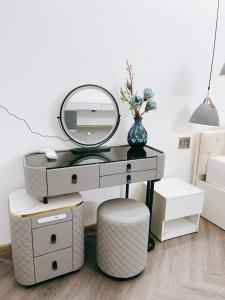 une coiffeuse avec un miroir et un tabouret dans l'établissement Kinh Do Homestay, à Hương Trà 18 autres photos