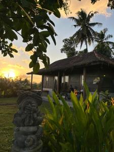 a stone statue in front of a house at Pondok Genitri in Bringkit