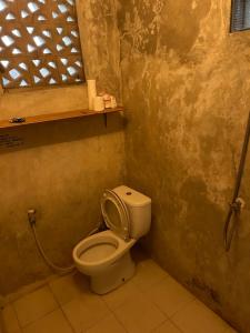 a small bathroom with a toilet and a window at Pondok Genitri in Bringkit +12 photos