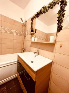 a bathroom with a sink and a mirror and a tub at Cluj City Vivo Apartament Ametist in Floreşti +17 photos