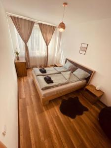 a bedroom with a bed and a wooden floor at Cluj City Vivo Apartament Ametist in Floreşti
