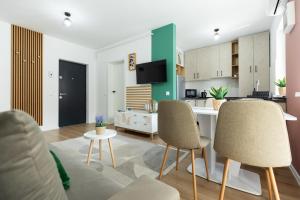a living room with two chairs and a kitchen at Green Blooming Studio in Baia Mare
