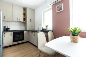 a kitchen with a white table and a white counter top at Green Blooming Studio in Baia Mare