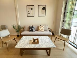 Una sala de estar con un sofá y una mesa de café. en Vélin - Chinatown, en Khlong San