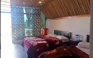 a bedroom with two beds and a window at Amar Bari Happy Valley Cottages by StayApart in Mangpu +6 photos