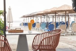 a table with two glasses of orange juice on the beach at Helios - Luxury by the Sea in Paralia Katerinis