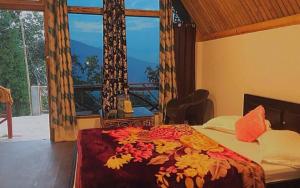 a bedroom with a bed with a large window at Amar Bari Happy Valley Cottages by StayApart in Mangpu