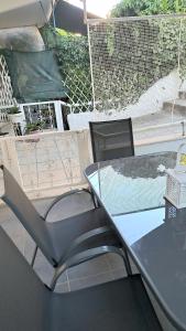 a glass table and chairs on a patio at SOLI Apartment in Neoi Epivates