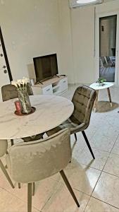 a living room with a table and chairs and a television at SOLI Apartment in Neoi Epivates