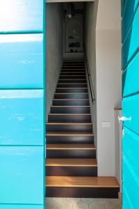 a staircase in a building with blue doors at B&B Fermata 106 da Carolina in Siculiana Marina