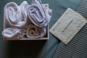 a box of towels sitting on a bed next to a napkin at B&B Fermata 106 da Carolina in Siculiana Marina