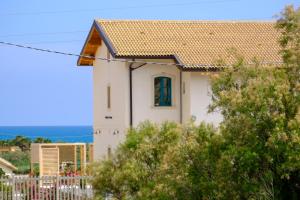 a white house with a brown roof at B&B Fermata 106 da Carolina in Siculiana Marina