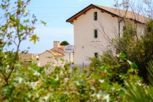 a white building with a sign on the side of it at B&B Fermata 106 da Carolina in Siculiana Marina