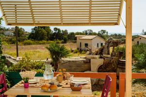 a wooden table with food on it in a backyard at B&B Fermata 106 da Carolina in Siculiana Marina