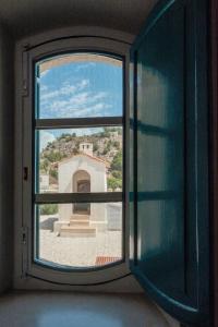a window with a view of a building through it at B&B Fermata 106 da Carolina in Siculiana Marina