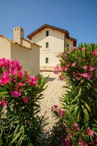 a house with pink flowers in front of a building at B&B Fermata 106 da Carolina in Siculiana Marina