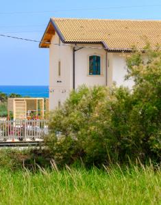 a house on the beach with the ocean in the background at B&B Fermata 106 da Carolina in Siculiana Marina