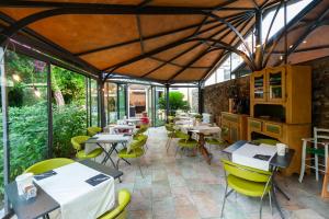 a restaurant with tables and chairs and windows at Hotel Melograno in Spotorno