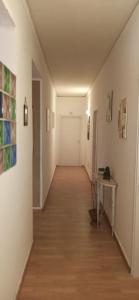 un lungo corridoio con pareti bianche e pavimenti in legno di new suite a Palermo