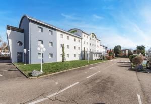 a large white building on the side of a street at B&B HOTEL Strasbourg Nord Mundolsheim in Mundolsheim