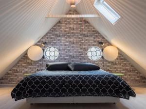 een slaapkamer met een zwart bed op een zolder bij Bed En Comfort in Vaassen