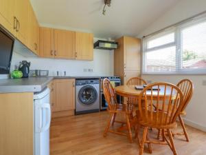 a kitchen with a table and chairs in a kitchen at Cornish Holiday at Atlantic Bays in Saint Merryn