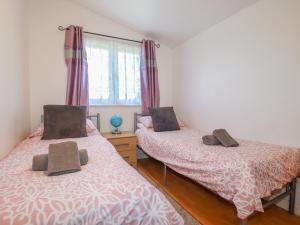 two twin beds in a room with a window at Cornish Holiday at Atlantic Bays in Saint Merryn