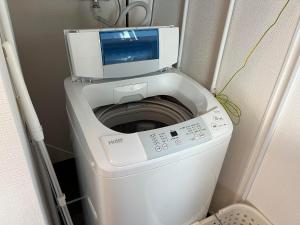 a washing machine with a tv on top of it at Otaru Eminabackpackers in Otaru