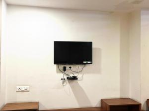 a flat screen tv hanging on a white wall at Hotel mauji's legacy in Allahābād