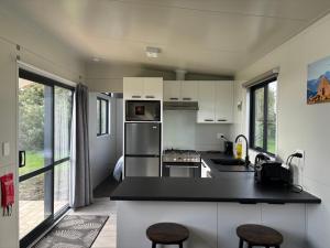 a kitchen with white cabinets and a black counter top at Tataraimaka Farmlet in Tataraimaka