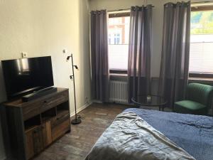 a bedroom with a bed and a flat screen tv at Time-Out Westerbauer TH19 in Hagen