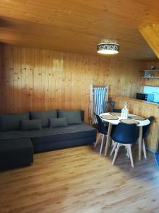 a living room with a couch and a table at Domki Mantras in Swarzewo