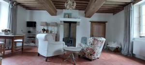 a living room with two chairs and a fireplace at Domaine de Vauvelle in Maux