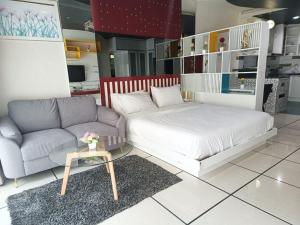 a living room with a bed and a couch at View Talay 6 Pattaya Beach Apartment by Honey in Pattaya