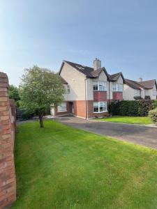 una casa con un prato verde davanti di 15 Cluain Caoin Nenagh a Nenagh