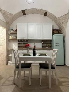 a kitchen with a table with two chairs and a refrigerator at Forno Mongelli 2.0 in Putignano